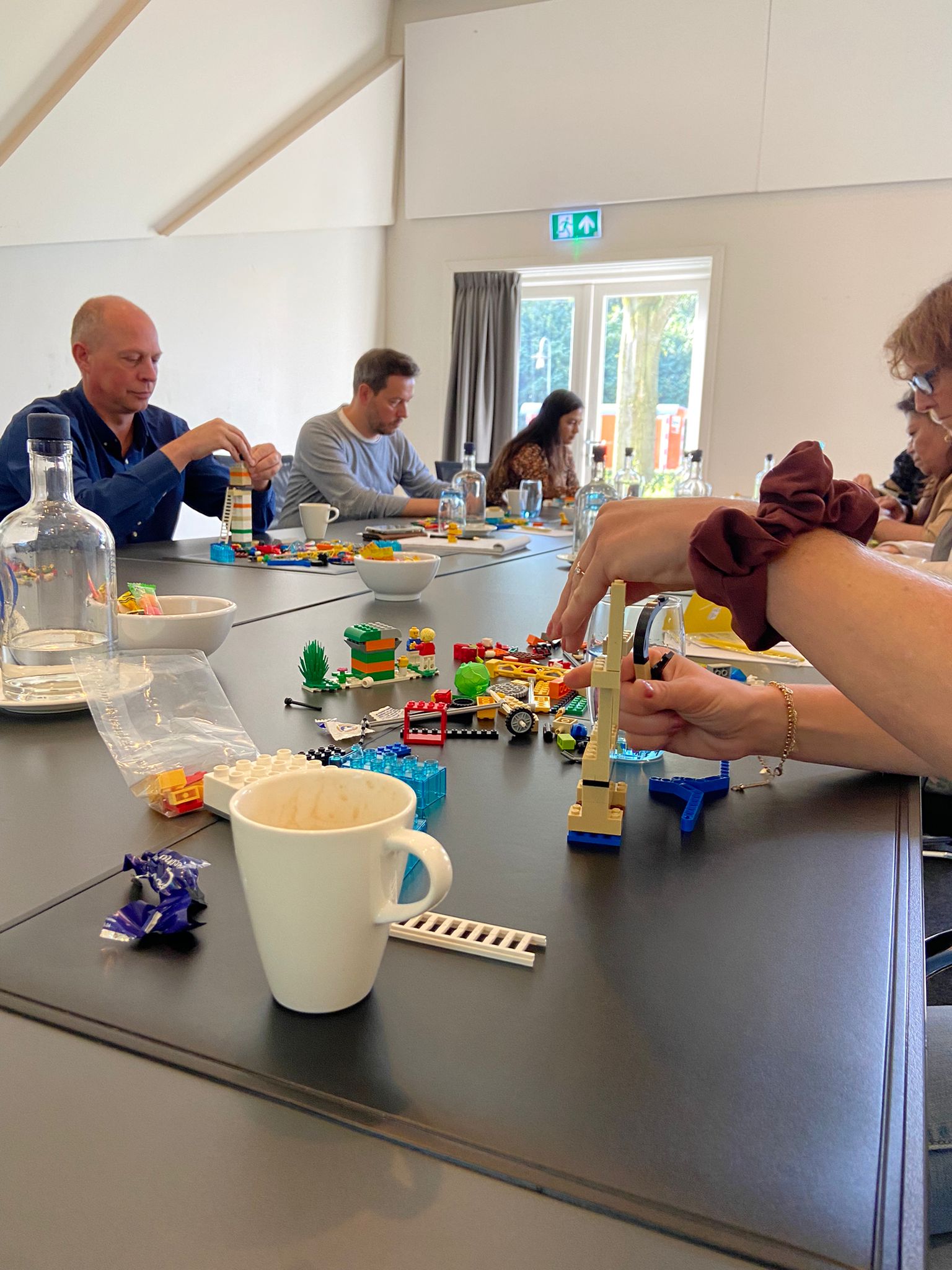 een groep mensen die rond een tafel zitten en een bordspel spelen