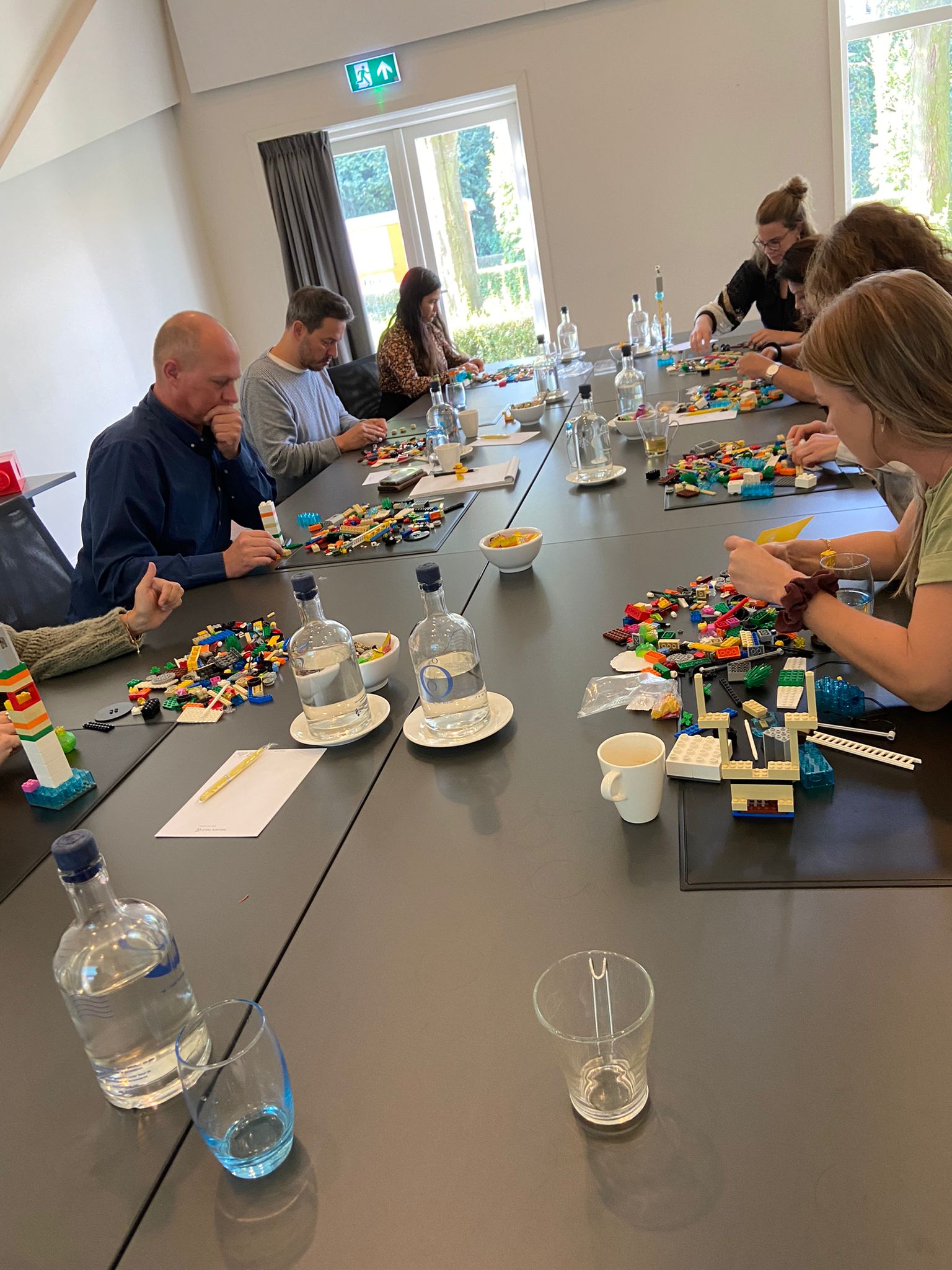een groep mensen die rond een tafel zitten en een bordspel spelen