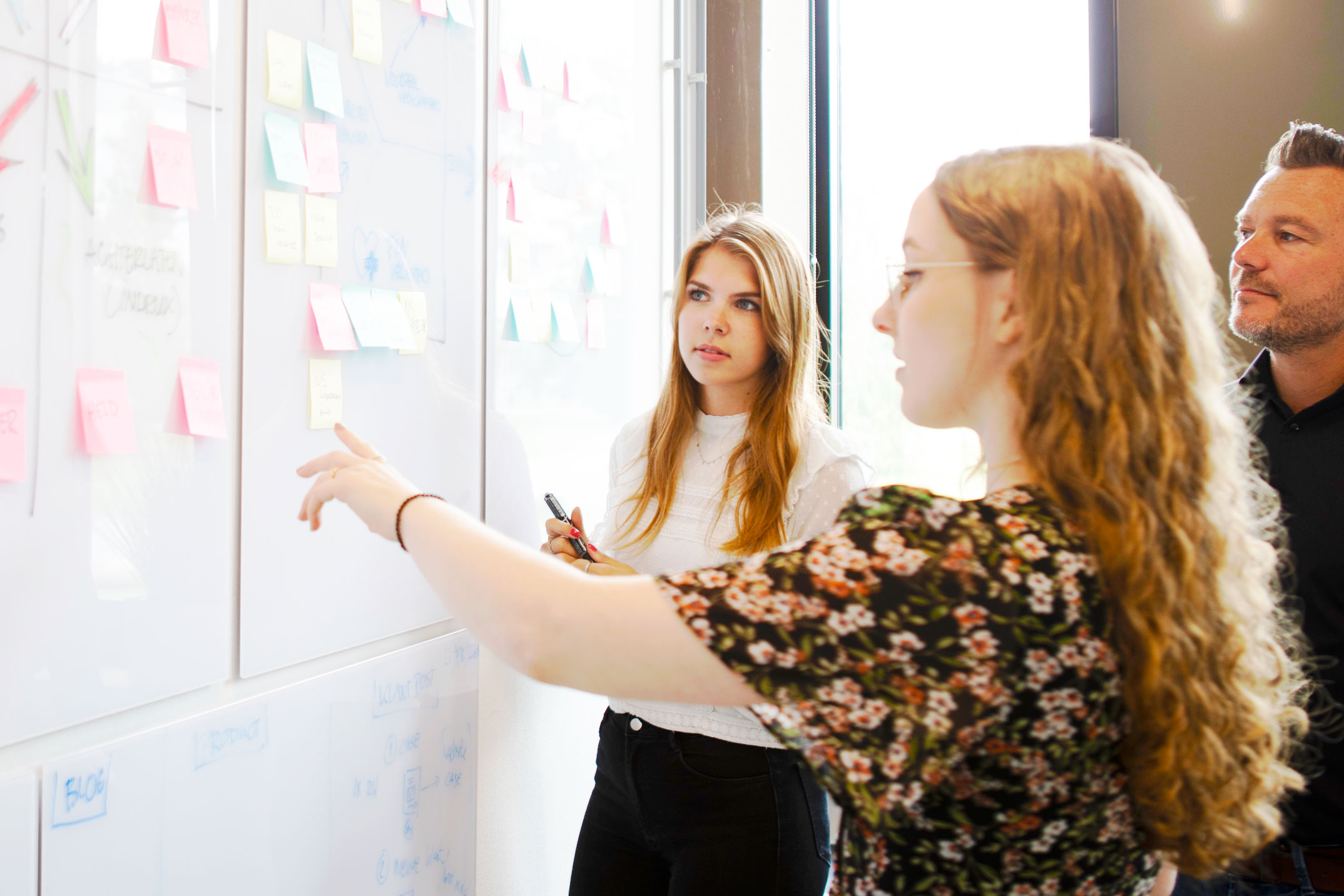 een persoon die naar een whiteboard wijst